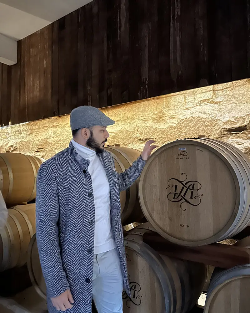 Alan numa adega, ao lado de barris